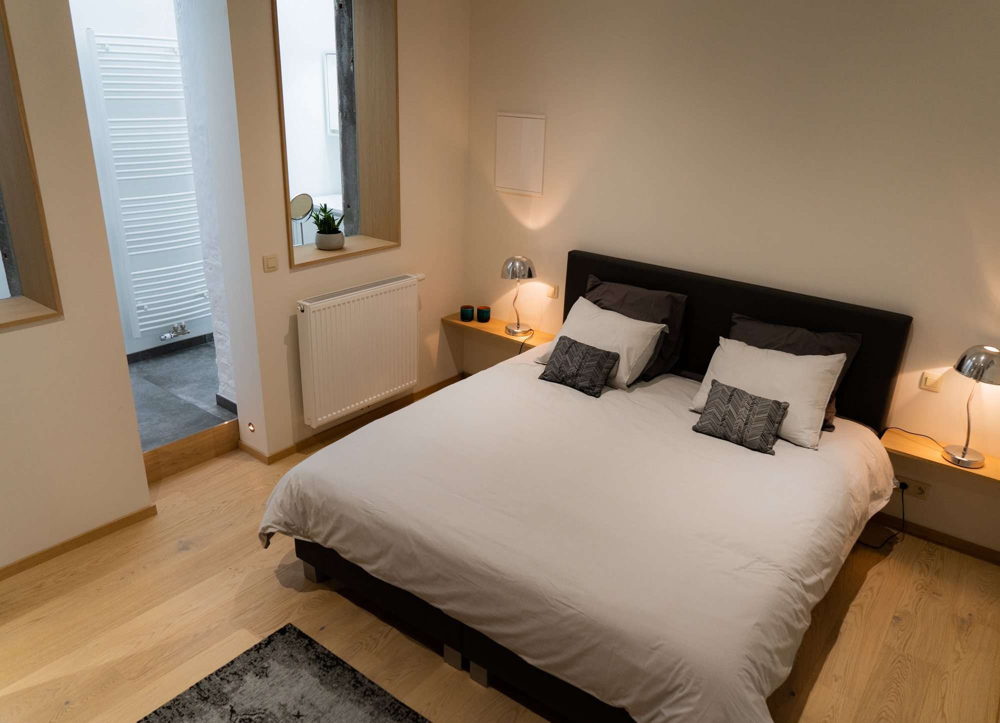 La chambre et son lit king-size 180x200, lampes de chevet allumées