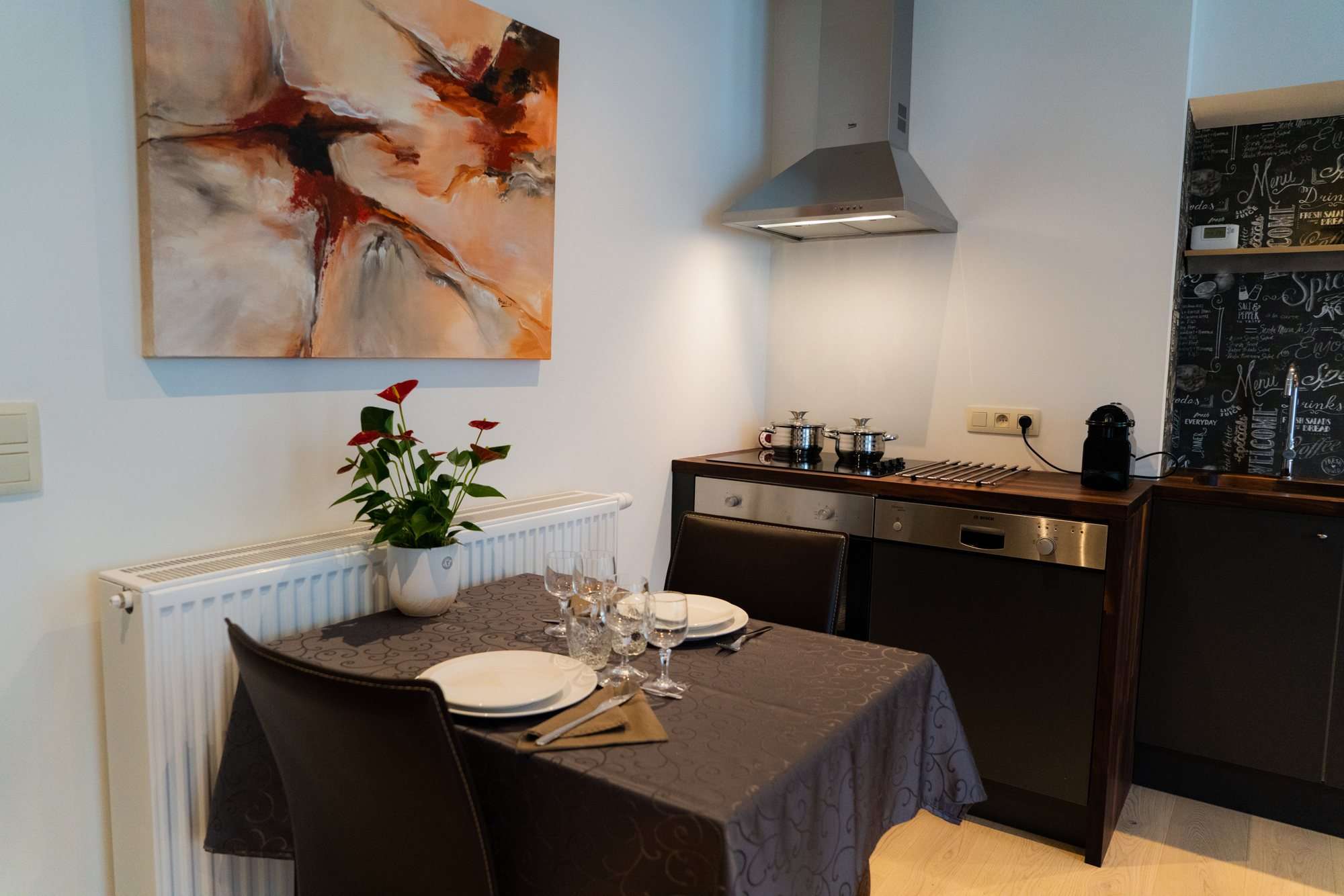 Table à manger dressée près de la cuisine équipée et de sa hotte